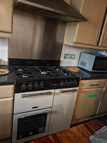 a kitchen with a stove top oven in a kitchen at king size bed -Room near Bournemouth Hospital shared bathroom in Bournemouth