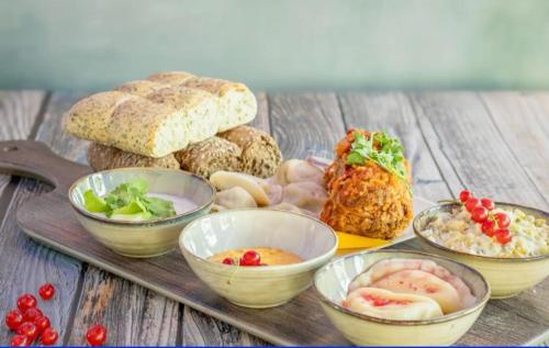 a tray of different types of food on a wooden table at Unieke Bed en Breakfast met historisch verhaal in Ferwert De K roon van Marijn in Ferwerd