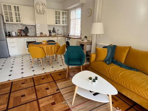 un salon avec un canapé jaune et une table dans l'établissement Sunny Gambetta with 3 air conditionings, à Nice