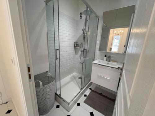 une salle de bain blanche avec une douche et un lavabo dans l'établissement Sunny Gambetta with 3 air conditionings, à Nice