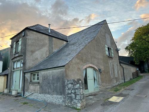 an old stone house with a black roof at The Old Dairy in Chepstow