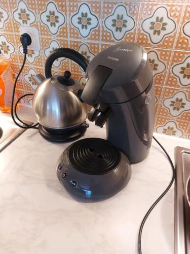 eine Kaffeemaschine und einen Wasserkocher auf der Theke in der Unterkunft Studio 2 a 4 pers proximité immédiate du centre in Châtel