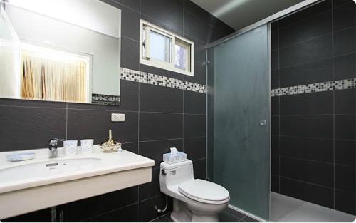 a bathroom with a toilet and a sink and a shower at Maple in Wujie