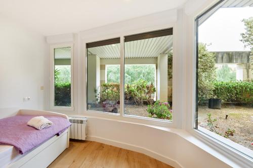 Cette chambre dispose de fenêtres et d'un lit avec une couverture violette. dans l'établissement Clínica Universitaria y Hospitales by Clabao, à Pampelune