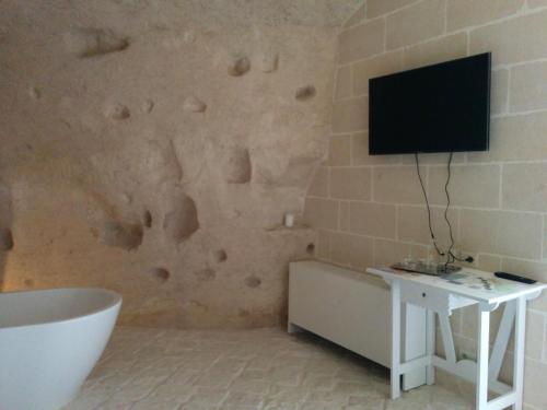 a bathroom with a tub and a tv on a wall at Le Dimore Dell' Idris in Matera