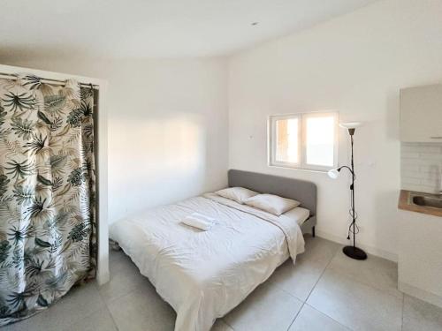 une chambre avec un lit dans une pièce blanche dans l'établissement Bazille, gare Saint Roch, à Montpellier