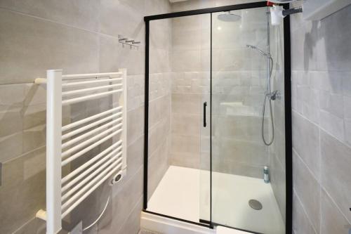 une douche avec une porte vitrée dans une salle de bain dans l'établissement Bazille, gare Saint Roch, à Montpellier