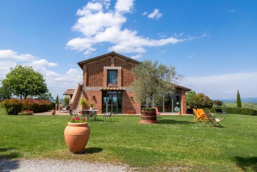 a house with a large pot in the yard at Casavacanze Vesta in Isola d'Arbia