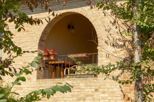 a window in a brick wall with a balcony at Casavacanze Vesta in Isola d'Arbia