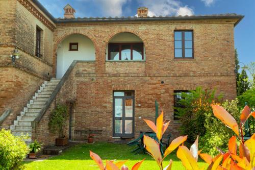 an old brick building with stairs and a window at Casavacanze Vesta in Isola d'Arbia