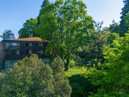 a building in the middle of some trees at Seegut Zeppelin in Friedrichshafen