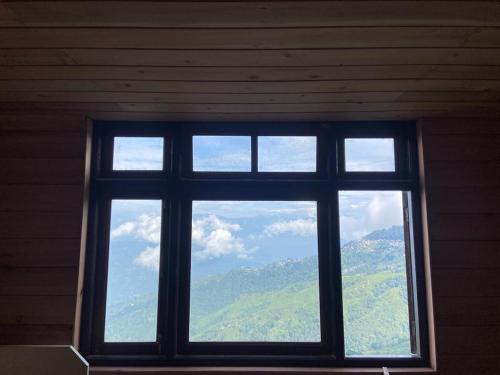 a window in a room with a view of a mountain at Norbu Thungkar Homestay in Darjeeling