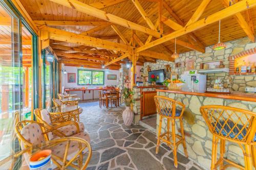 a living room with a bar and some chairs at Kastro Studios Apartments in Myrtos