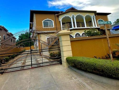 a house with a gate in front of it at White House by White River in Ocho Rios