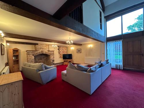 a living room with two couches and a fireplace at The Old Dairy in Chepstow