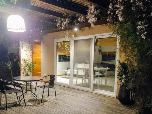 eine Terrasse mit Tisch und Stühlen auf einem Deck in der Unterkunft La Escondida in Valeria del Mar