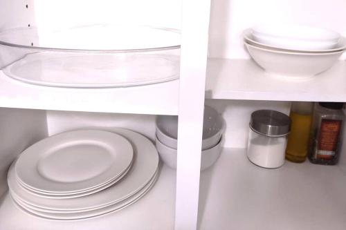 a shelf with white plates and other items on it at Basement Waterloo Near 24-7 Restraints in Waterloo