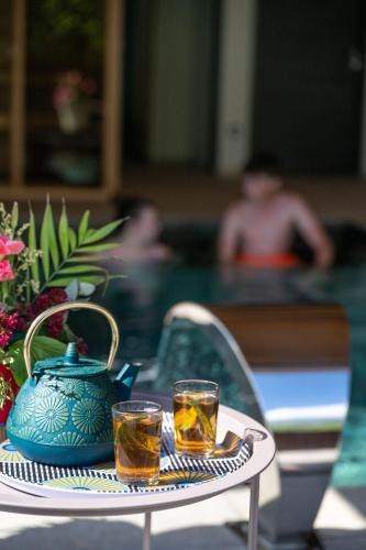 a table with two glasses of tea and a teapot at Chalet Soleil Bœuf et Spa de l'adouss in Saint-Jean-Saint-Nicolas