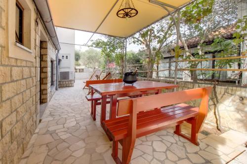 a patio with benches and a table and an umbrella at Apartments Franjo in Mali Lošinj