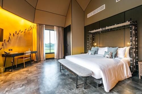 a large bedroom with a large bed and a desk at THANN Wellness Destination in Phra Nakhon Si Ayutthaya