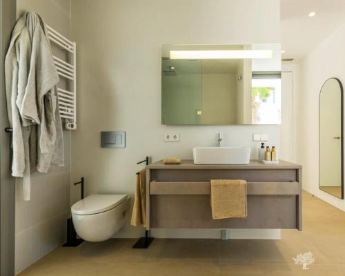 ein Badezimmer mit Waschbecken, Toilette und Spiegel in der Unterkunft LIMA 18 , Las Colinas Golf, Orihuela costa in Orihuela