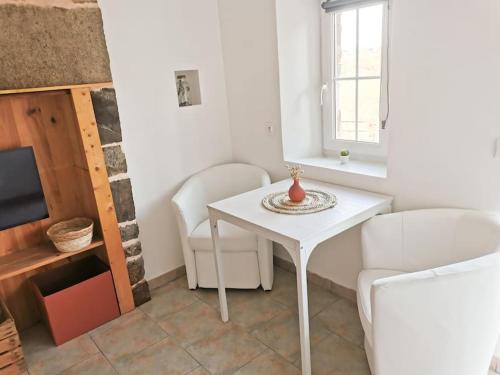 - un salon avec une table blanche et deux chaises dans l'établissement Gîte Le Rouge Gorge 2 personnes, à Sainte-Marie-Laumont