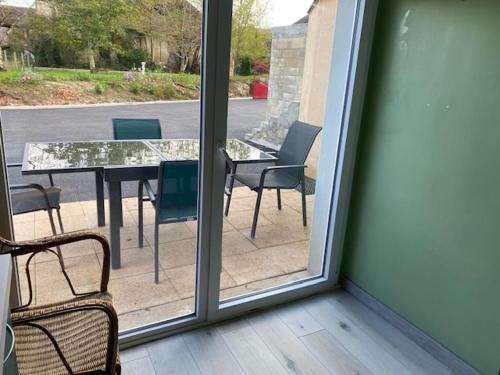 d'une terrasse avec une table et des chaises à l'extérieur de la fenêtre. dans l'établissement Au calme, à Villersérine
