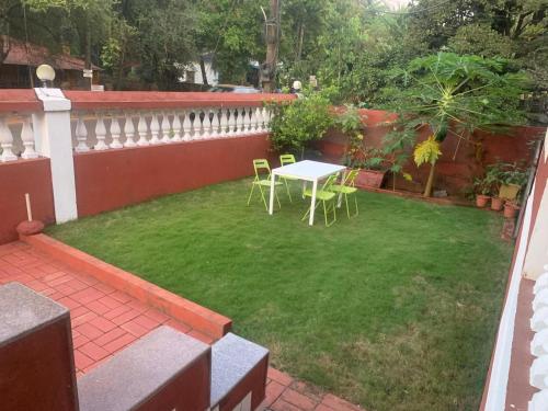 a patio with a table and chairs in a yard at NomadGao Vila Nova - Comfort, Great Views, Fast WiFi & Interesting People in Anjuna
