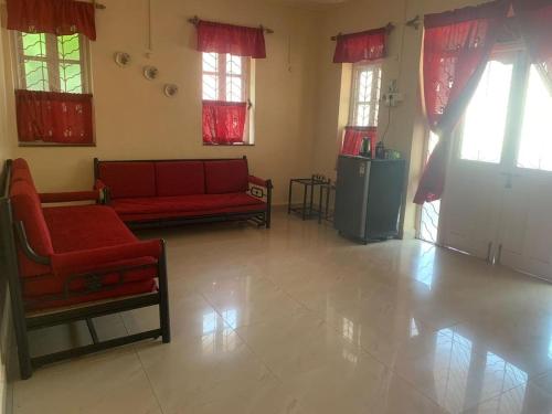 a living room with a red couch and a refrigerator at NomadGao Vila Nova - Comfort, Great Views, Fast WiFi & Interesting People in Anjuna