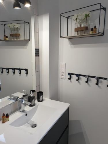 a white bathroom with a sink and a mirror at Maison de charme avec jardin au bord de l'Eure in Le Vaudreuil