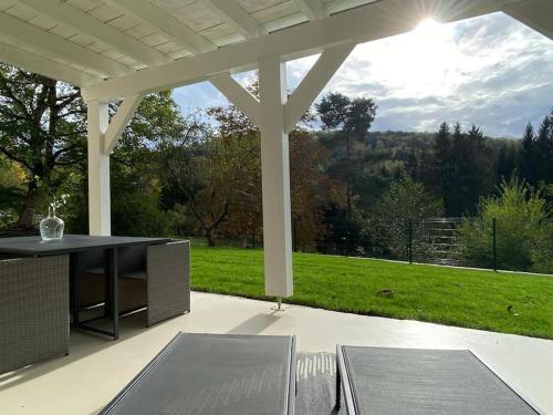 a pavilion with a table and chairs on a patio at Gîte Rénové en bordure de forêt in Laveline