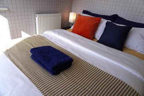 a bed with a blue towel sitting on top of it at Luxury Rooms - Pick a Room - Free Parking & Kitchen Access, Near Etihad Stadium, The Coop Live & Piccadilly Station, Manchester in Manchester