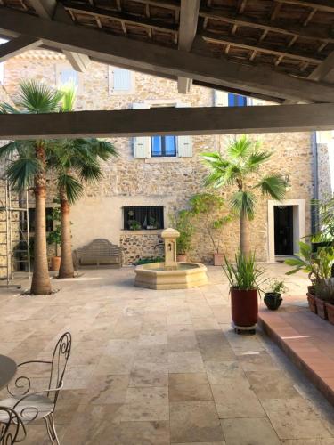 a courtyard with palm trees and a fountain at Maison Mia Majorelle in Roujan