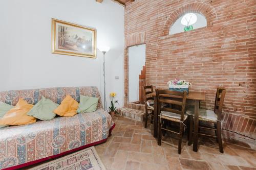 チェルタルドにあるBorgo Antico Residenceのレンガの壁、リビングルーム(ソファ、テーブル付)