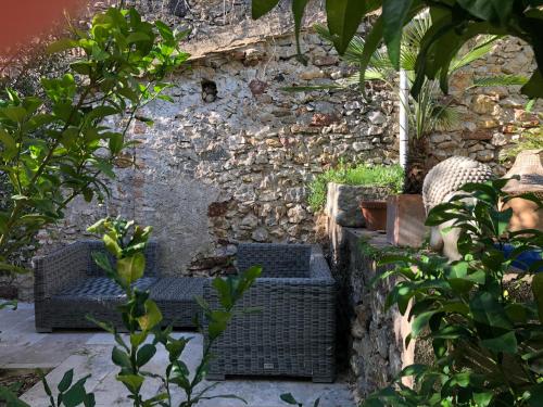 a garden with four wicker chairs and a stone wall at Maison Mia Majorelle in Roujan