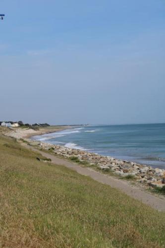 une plage avec l'océan en arrière-plan dans l'établissement instant de rêve entre dune et mer, à Saint-Jean-de-la-Rivière