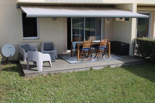 une terrasse avec une table et des chaises dans une maison dans l'établissement instant de rêve entre dune et mer, à Saint-Jean-de-la-Rivière