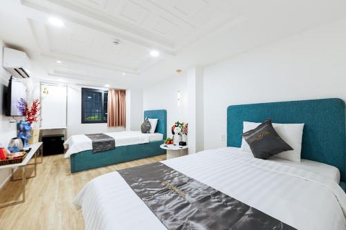 a hotel room with two beds and a couch at Le Vu Hotel in Ho Chi Minh City