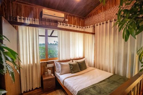 een slaapkamer met een bed in een kamer met een raam bij Habba Dates Villa Near Chikkaballapur in Bāgepalli