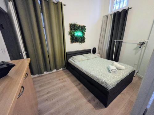 une petite chambre avec un lit dans une pièce dans l'établissement L'appart Rouennais, à Rouen