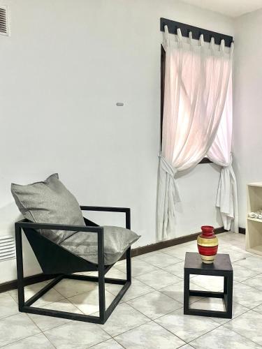a chair and a table in a room with a window at Espacio Seven Mendoza in Guaymallen