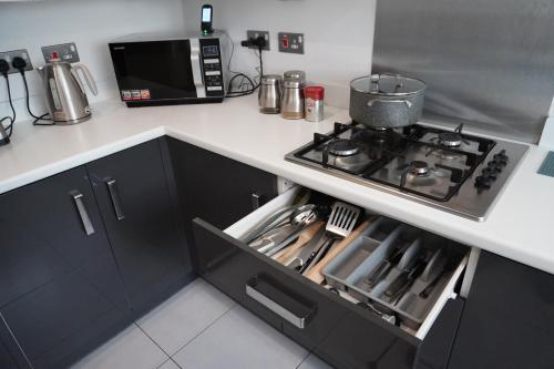 a kitchen with a stove and a microwave at Luxury Rooms - Pick a Room - Free Parking & Kitchen Access, Near Etihad Stadium, The Coop Live & Piccadilly Station, Manchester in Manchester