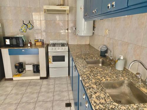 a kitchen with a sink and a stove at Espacio Seven Mendoza in Guaymallen