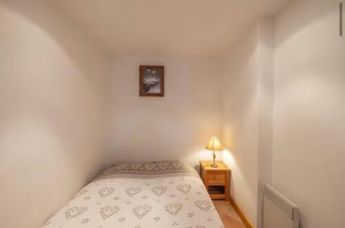 - une petite chambre avec un lit et une lampe dans l'établissement Marie Mont Blanc vue Mont Blanc, à Saint-Gervais-les-Bains