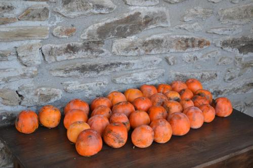 a pile of oranges sitting on a wooden table at Casa de Onor in Rio de Onor