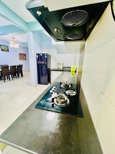 a kitchen with a stove top in a room at Khalifah Homestay Penaga in Penaga