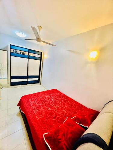 a living room with a red blanket on a couch at Khalifah Homestay Penaga in Penaga