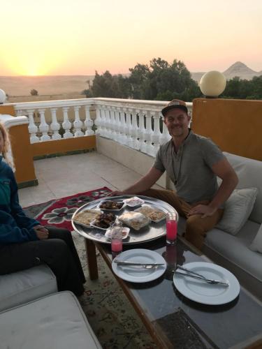 a man sitting at a table with a plate of food at Sakkara pyramid inn hotel in Cairo