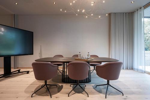 a dining room with a table and chairs and a tv at Seegut Zeppelin in Friedrichshafen
