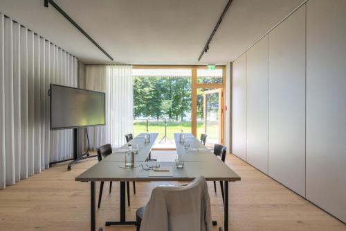 a conference room with tables and chairs and a screen at Seegut Zeppelin in Friedrichshafen